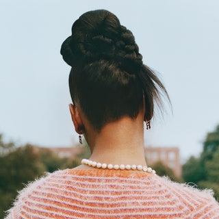 Three side by side images of the back of a woman with her hair up in a bun wearing a pearl necklace and striped white and orange sweater