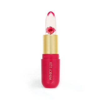 open gold and pink tube of a clear winky lux lip balm with a pink flower encased in the balm